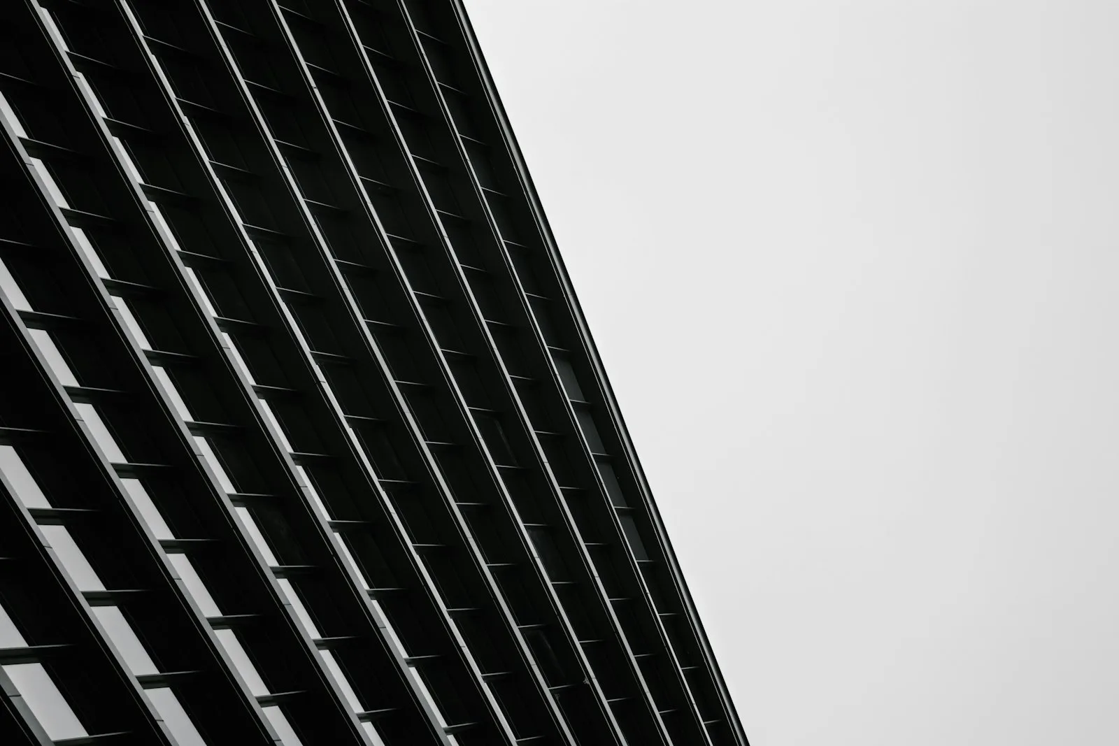 Facciata a lamelle scure di un edificio direzionale, vista dal basso