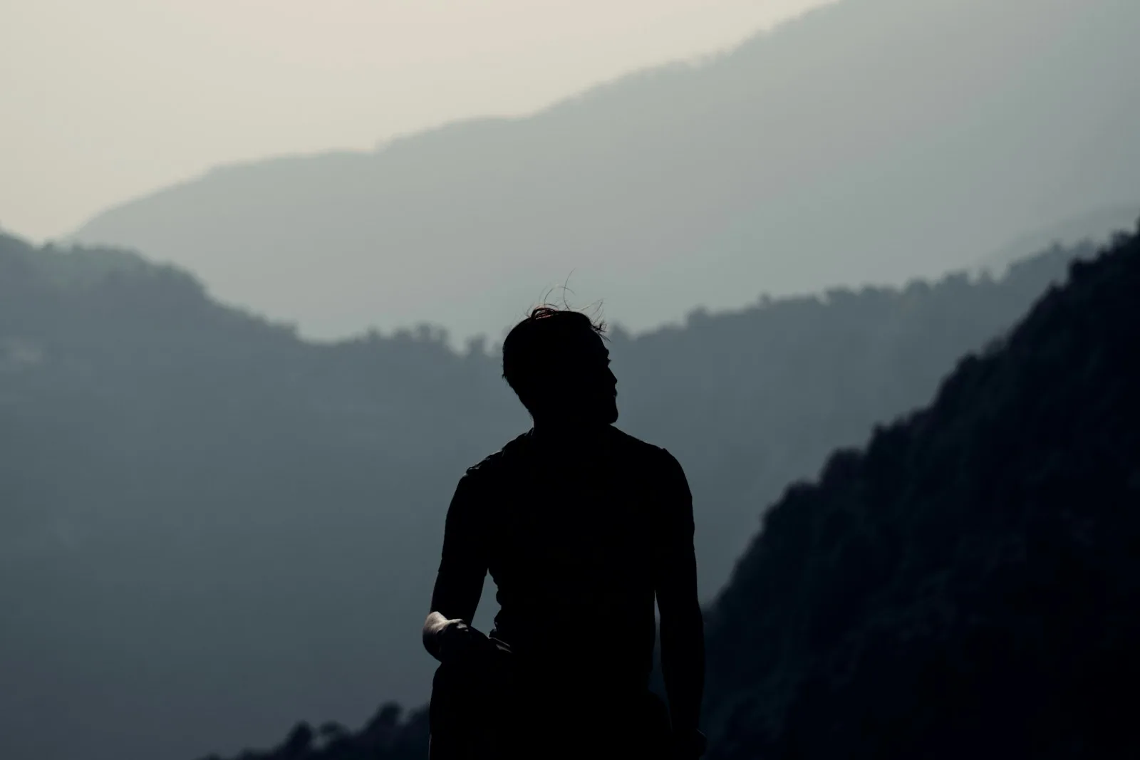 Atleta indossa la maglia tecnica prima di allenarsi, montagne sullo sfondo all’alba